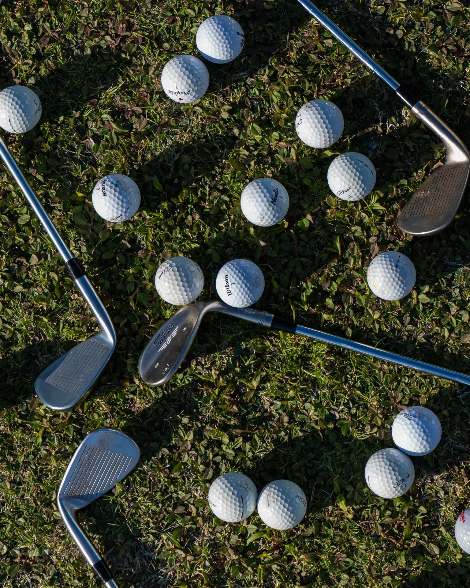 Wedges and golf balls on the grass